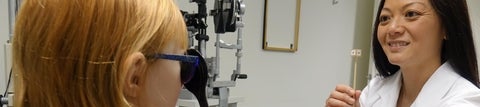 Optometrist testing a child's binocular vision