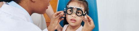 Child wearing trial glasses frame.