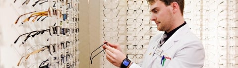 A student examines an eyeglass frame