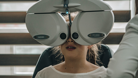Child looks through an eye testing device