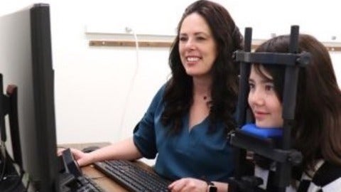 Dr. Krista Kelly tracking a child patient's eyes while reading