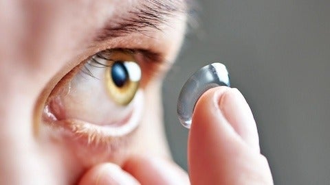 Close up of person putting contact in eye
