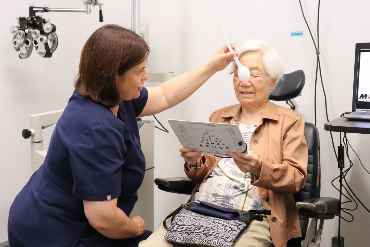 Dr. Tammy Labreche examines the close vision of an older woman