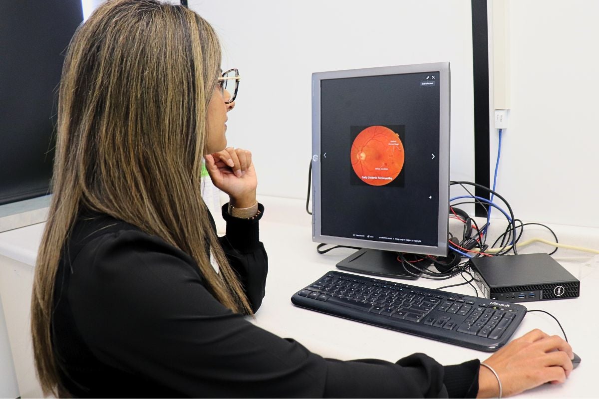Dr. Sandip Randhawa examining a fundus photo.