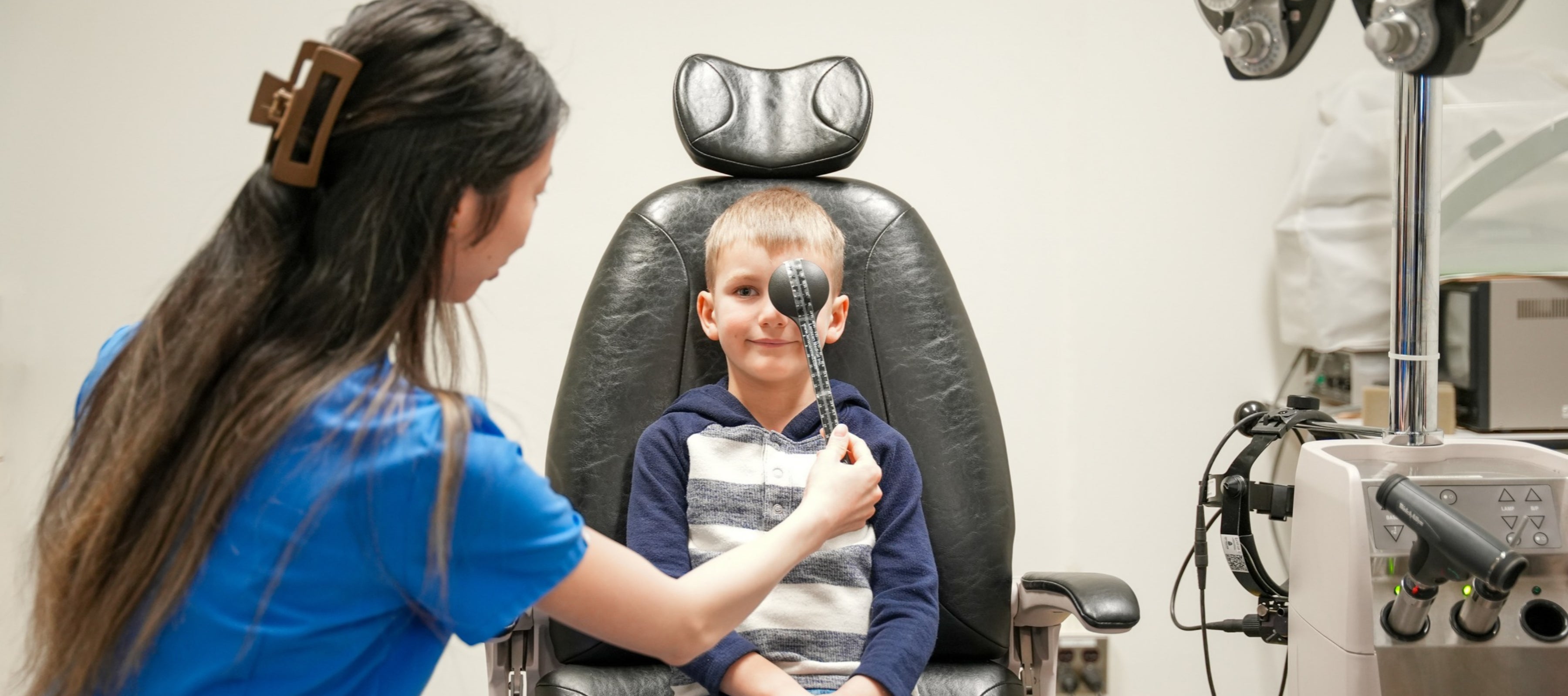 Child getting visual acuity test with eye occluder