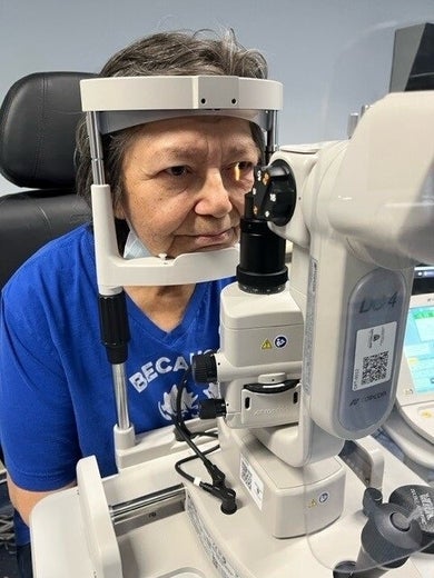 Woman receives an eye exam using a slit lamp
