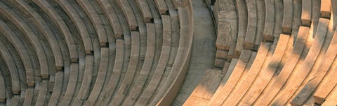 Close-up of curved marble seating in an ancient Greek theatre, representing upcoming gatherings and scholarly exchange.