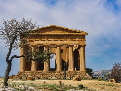 Front view of the Temple of Concordia in Agrigento Sicily, a well-preserved ancient Greek Doric temple under a clear blue sky.