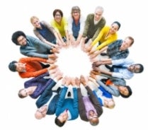 Group of people standing in a circle with their hands in front of them
