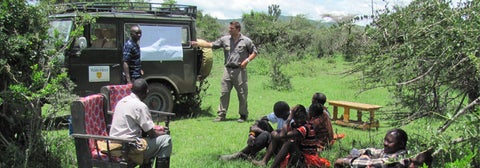 Student describing image on side of UW Jeep to local Kenyans