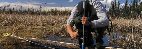 Student taking precise measurements in wetlands topography