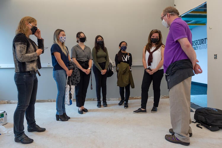 a group of people standing in an unfinished room