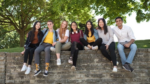 Group of undergraduate students posing for a group photograph outside on campus.