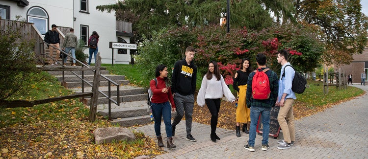 Six students standing outside Graduate House