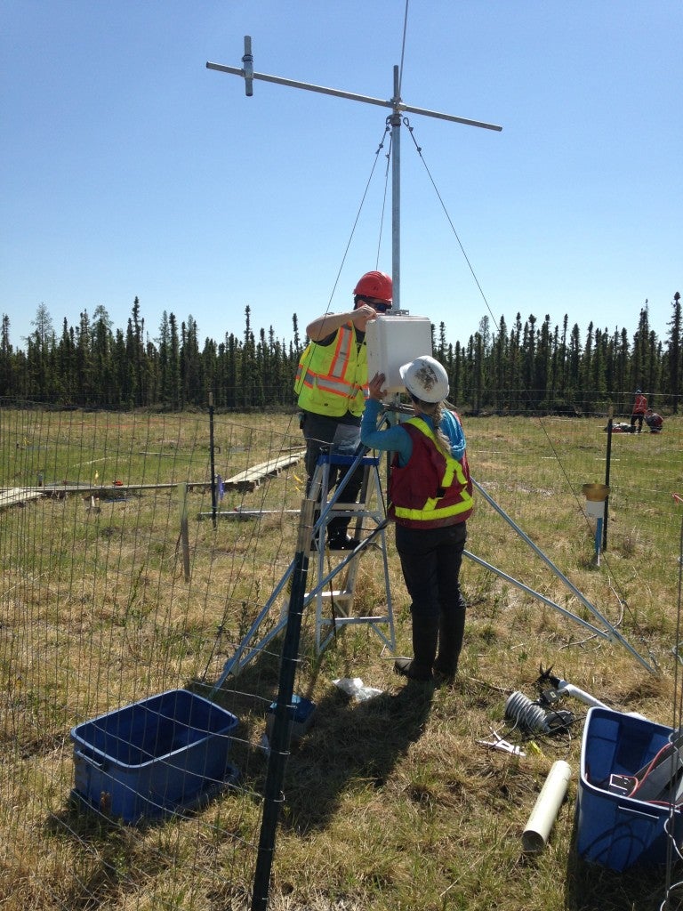 Researchers setting up a meteorological station