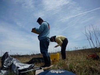 Two researchers measure carbon flux in a peatland