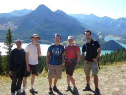 Five people posing in the mountains.