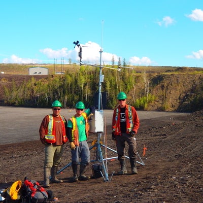 Researchers standing next to a slope meteorological station