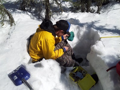   Researcher Eric measuring a snow pit