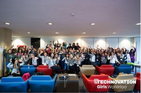 A photo all all the technovation girls+ putting their hands in the air.