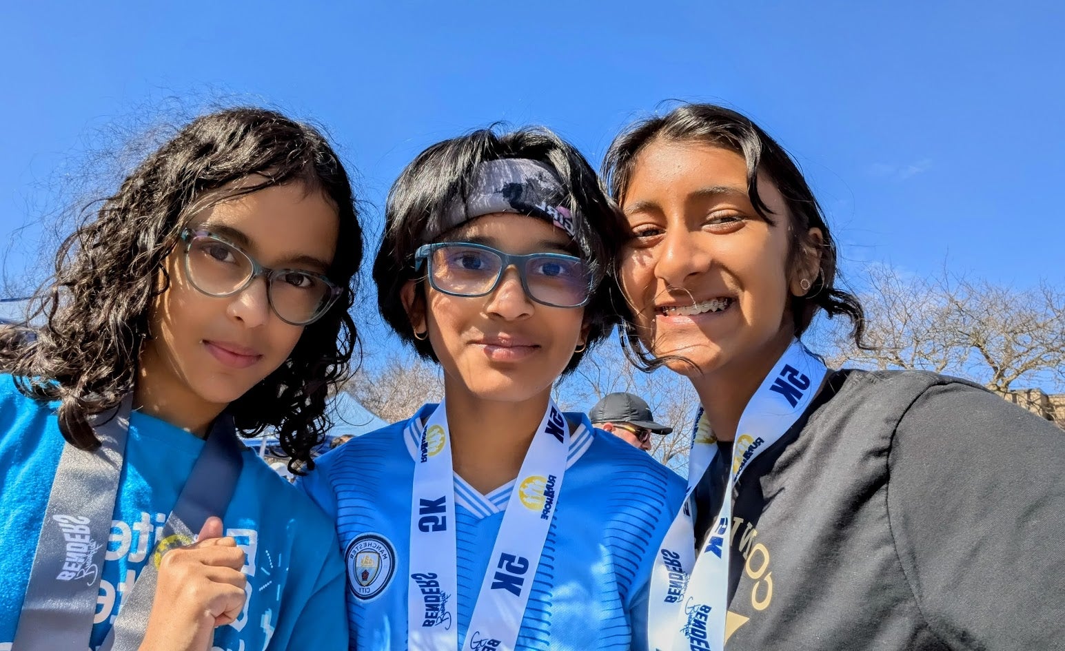 3 members of team balance beam taking a selfie, smiling at the camera