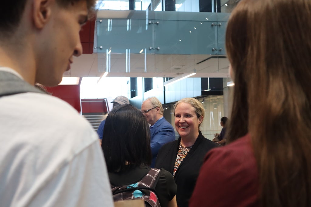 Women in a crowd speaking to students