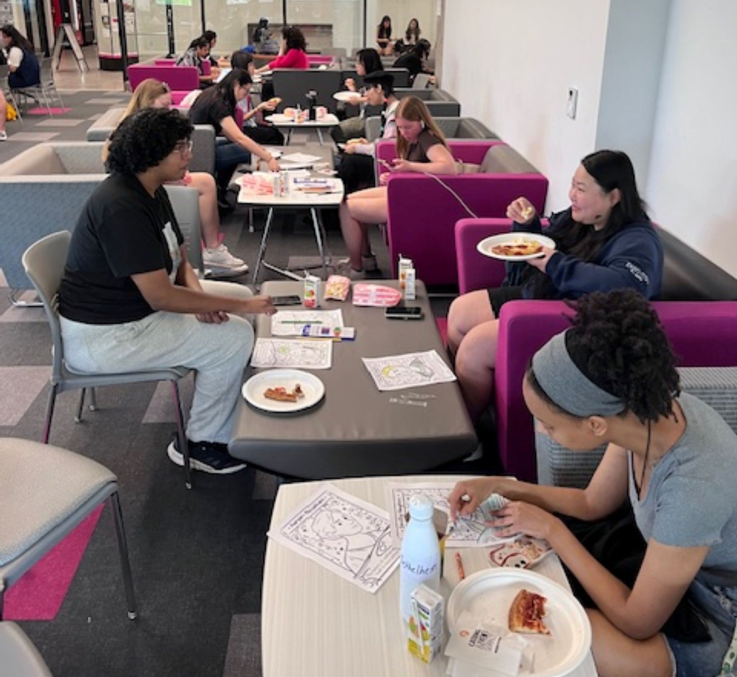 Students colouring and eating pizza