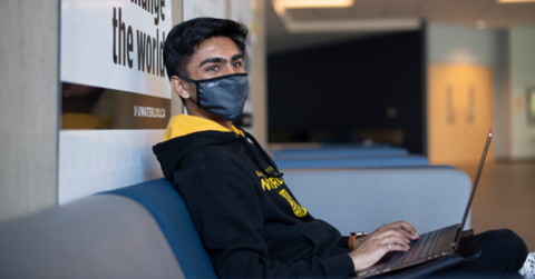 Student wearing a mask while working on laptop