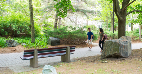 Two students walking through garden on campus