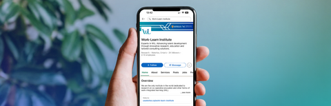 Person holding phone with WxL LinkedIn home screen