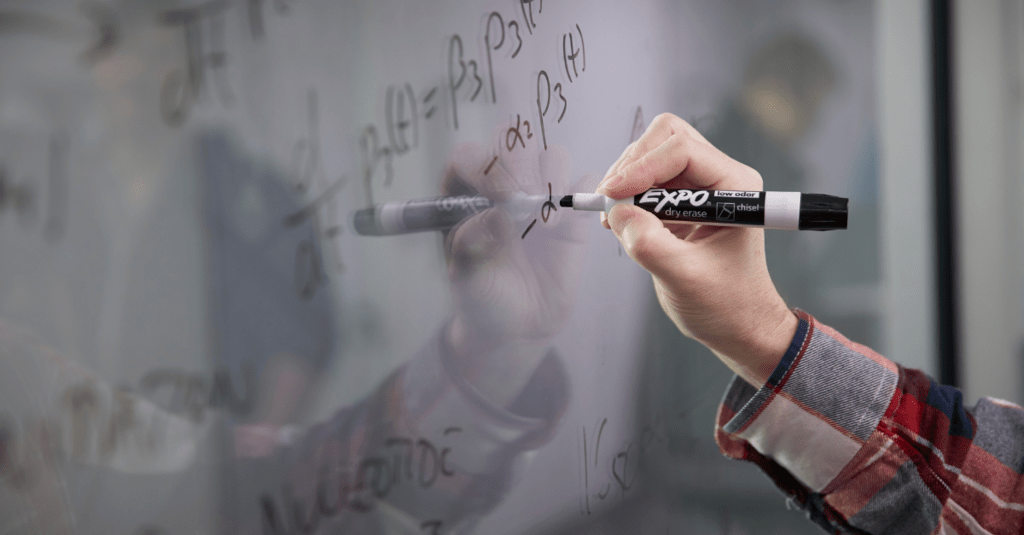Person writing on a white board