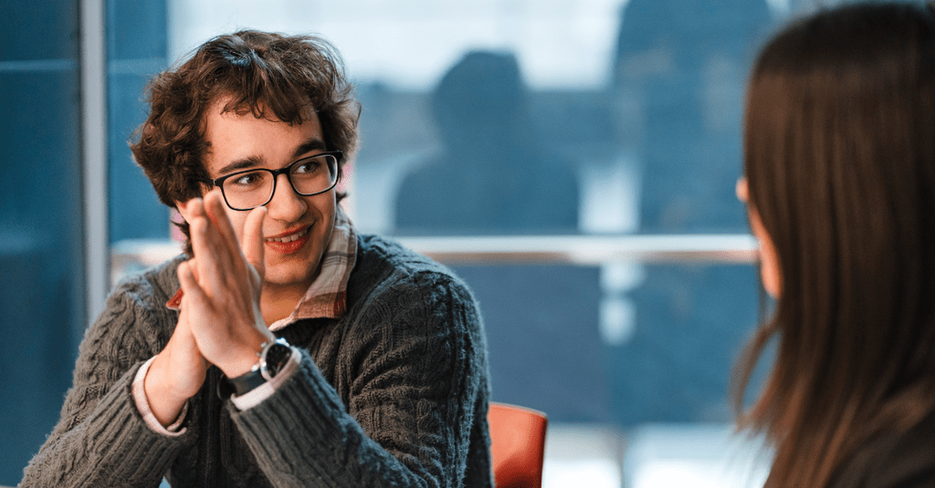 Male student talking to supervisor who's face is not visible 