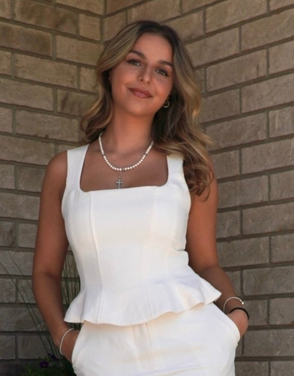 Ana Ljujic smiling in a white outfit