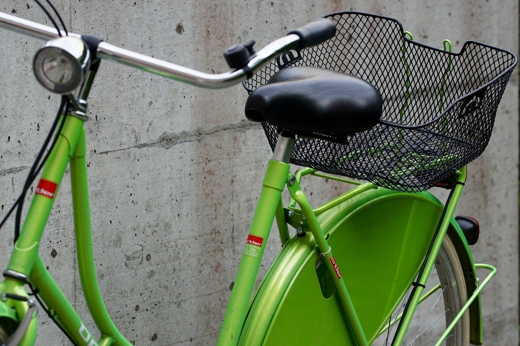 green bike beside a wall 