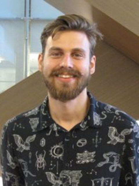 Image of Nikolay Videnov wearing a dark coloured shirt and smiling at the camera