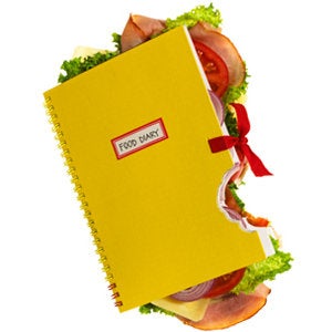 A yellow note book stuffed with food that has a bite taken out of it