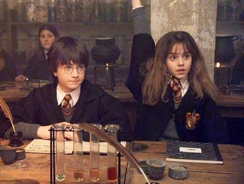 An image of Harry Potter and Hermione Granger sitting at a desk, with Hermione's hand raised