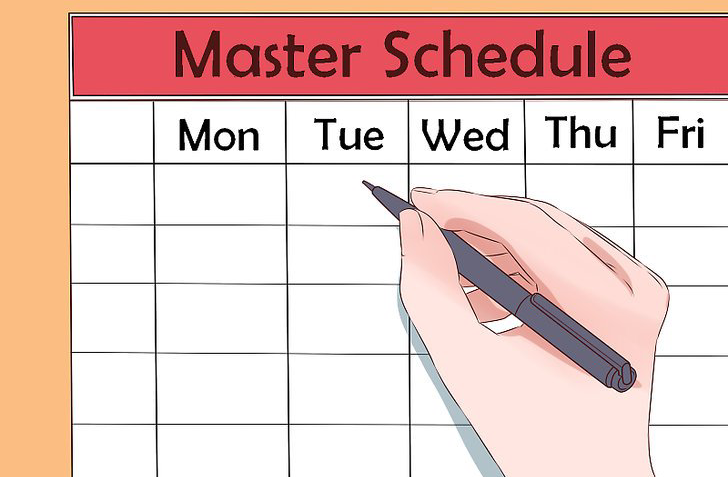 Hand holding pen positioned over a master schedule 