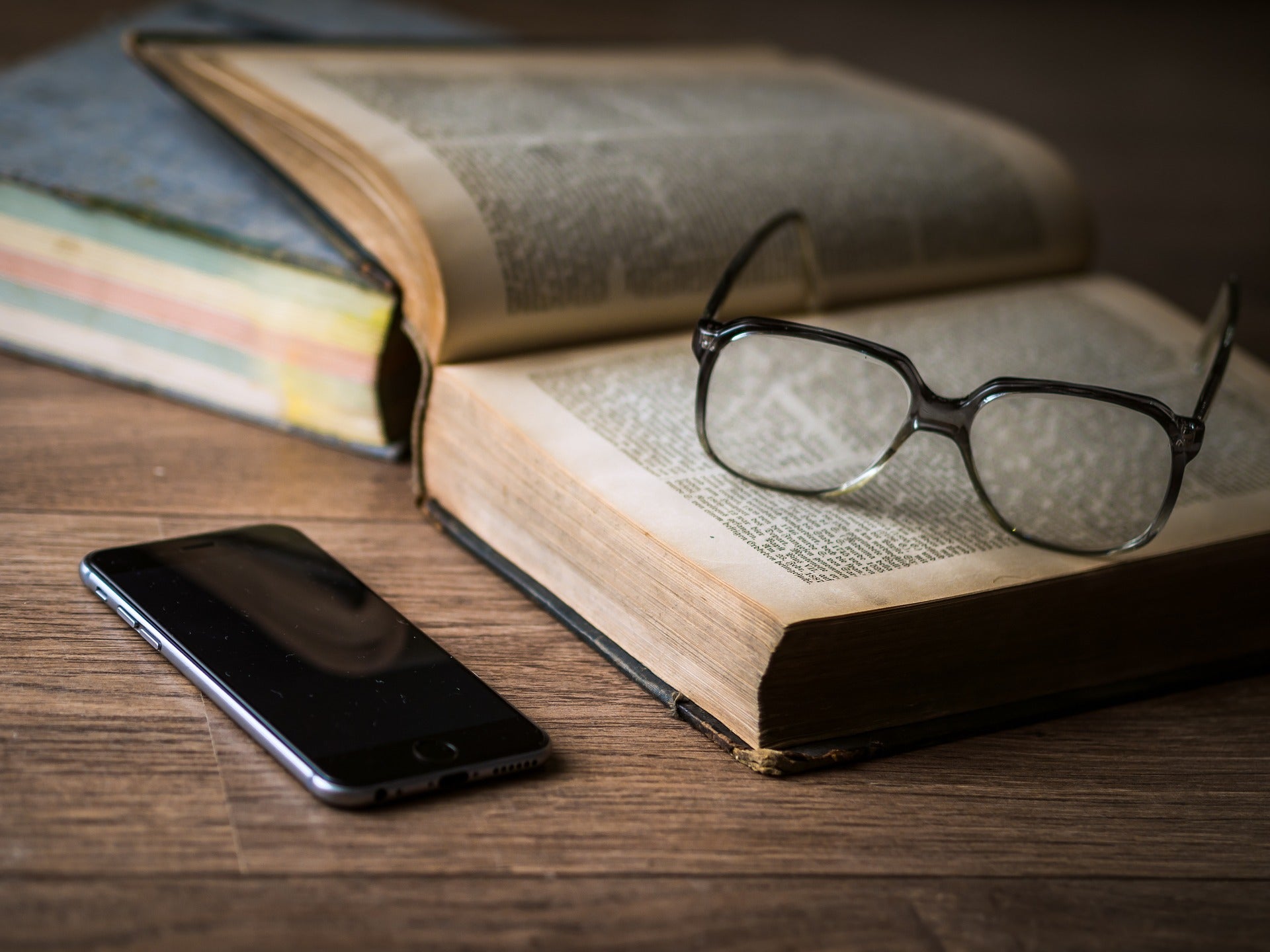 A cellphone next to an open book