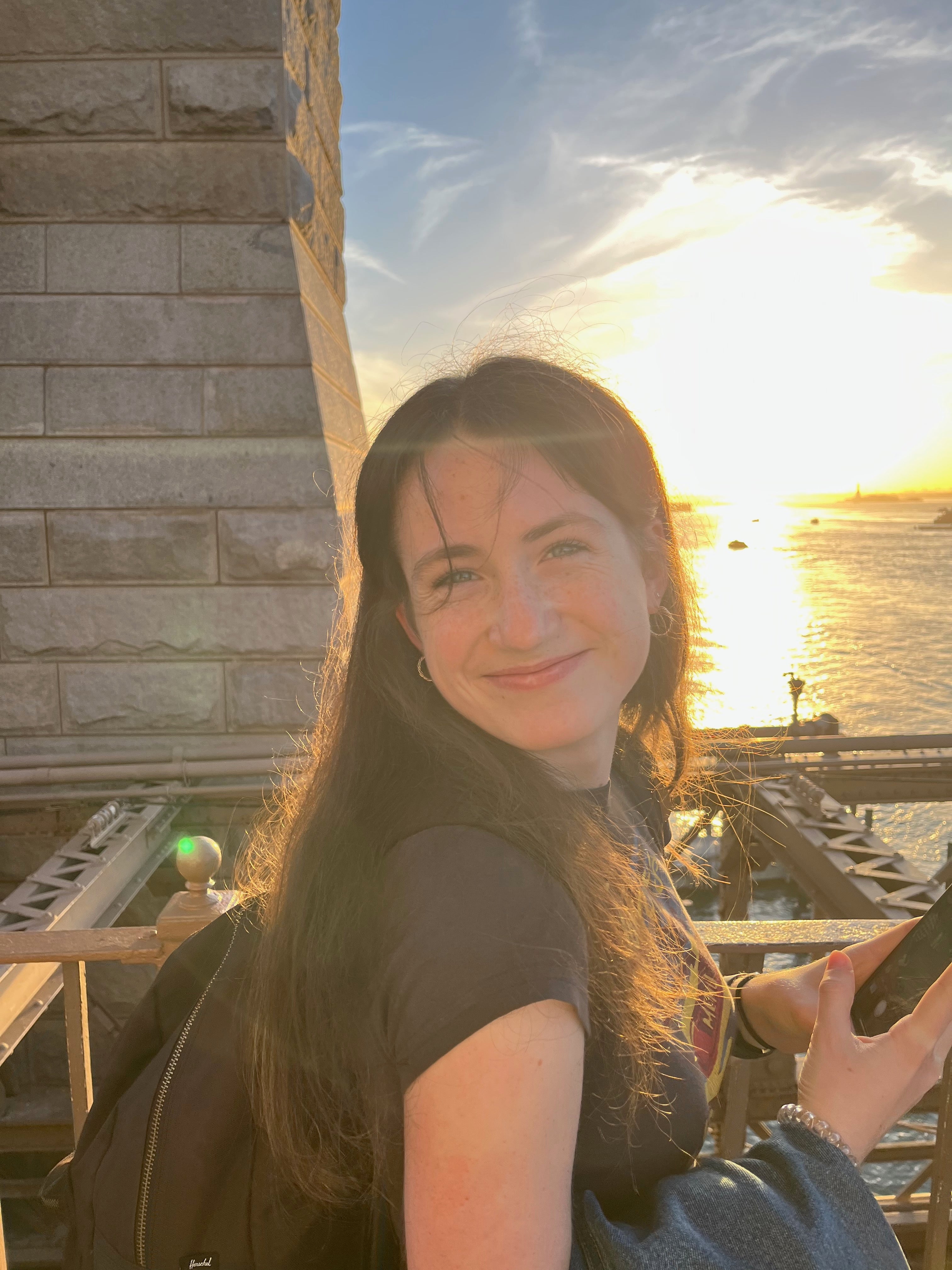 A photo of Lilah wearing black top smiling with a sunny background